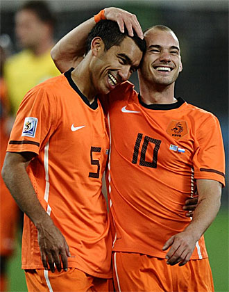 Sneijder se abraza a Van Bronckhorst tras derrotar a Uruguay.