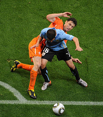 Van Bommel, en un lance con el uruguayo Pereira en la semifinal.
