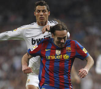 Cristiano Ronaldo disputa un balon a Gabi Milito en el pasado Real Madrid-FC Barcelona.
