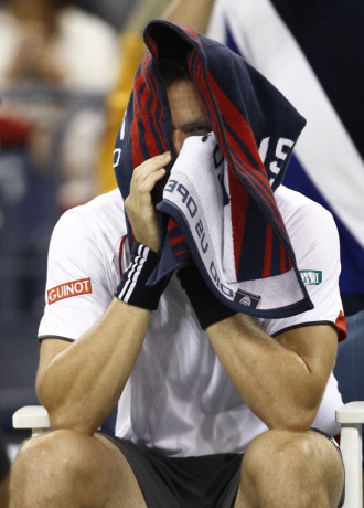 Soderling se cubre la cara durante un descanso en el partido frente a Federer.