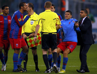 Varios jugadores del Steaua protestan a Marcin Borsky pasados siete minutos de descuento.