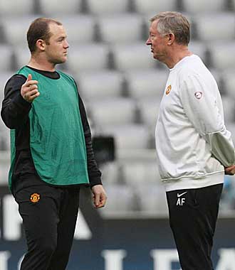 Rooney y Ferguson charlan durante un entrenamiento de la Champions League.