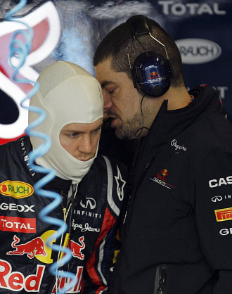 Vettel atiende las explicaciones de uno de sus mecnicos.