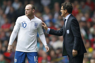 Capello dialoga con Rooney durante el partido frente a Gales.