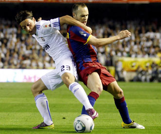 Ozil luchando con Iniesta en la final de Copa