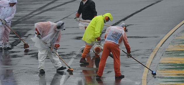 Operarios intentar secar la pista, sin xito / REUTERS
