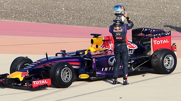 Vettel, extintor en mano, junto a su Red Bull averiado