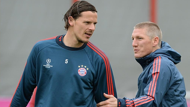 Van Buyten habla con Schweinsteiger en un entrenamiento del Bayern. / AFP