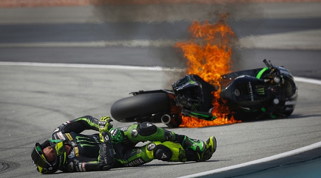 Pol Esparger yace en el suelo con cara de dolor mientras su moto se quema / MOTOGP