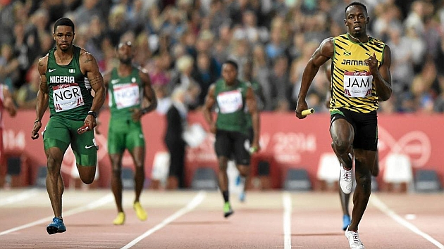 Mark Jelks (Nigeria) y Usain Bolt, en los 4x100 de Glasgow en 2014. Foto: AFP
