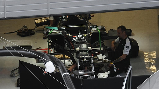 Un mecnico de Mclaren revisa los dao en el coche de Alonso / RV RACINGPRESS