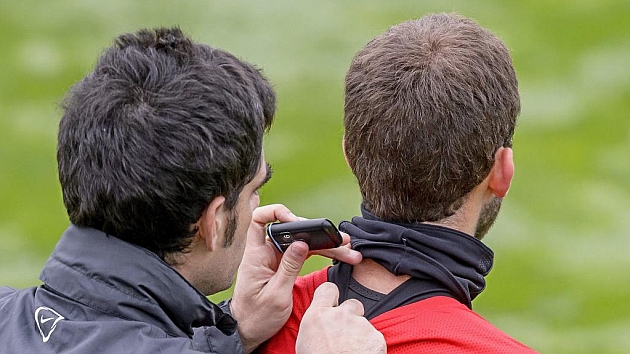 Un fisio coloca un dispositivo electrnico de rendimiento a un futbolista durante un entrenamiento
