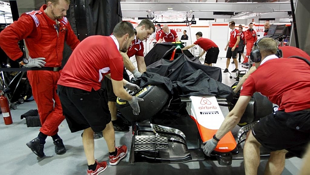 Miembros del equipo Manor introducen el coche de Rossi en el garaje despus del accidente.