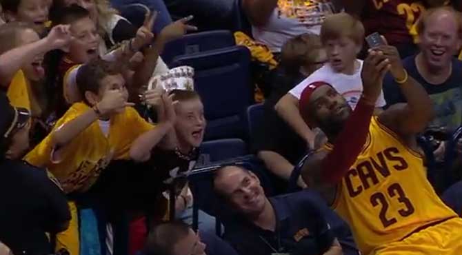 El Rey LeBron se hace un selfie con unos aficionados en pleno partido