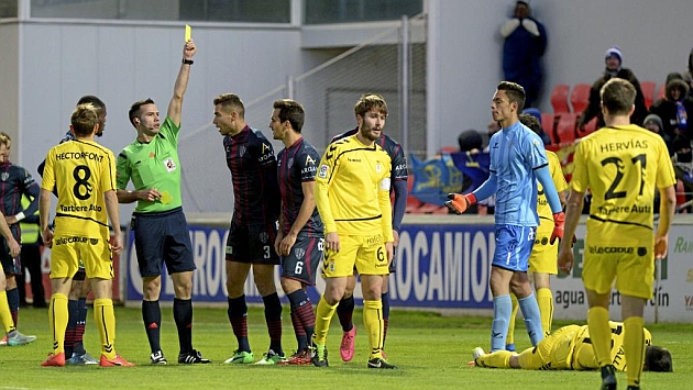 De la Fuente Ramos muestra una tarjeta amarilla durante el Huesca-Oviedo