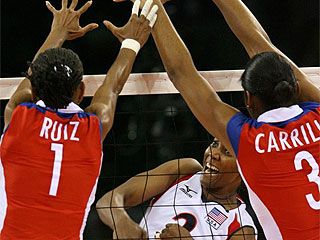 Dos jugadoras cubanas saltan al bloqueo de una estadounidense (Foto: AFP)